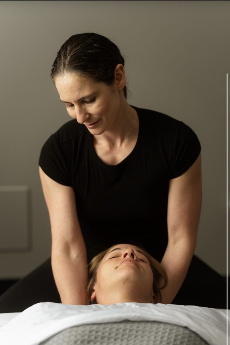 Vivian cradling a client's neck and head at the top of the table